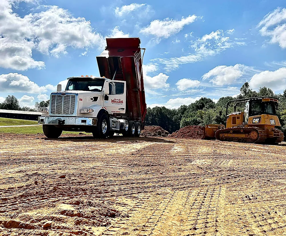 Tri-axle dump truck and dozer on a job site