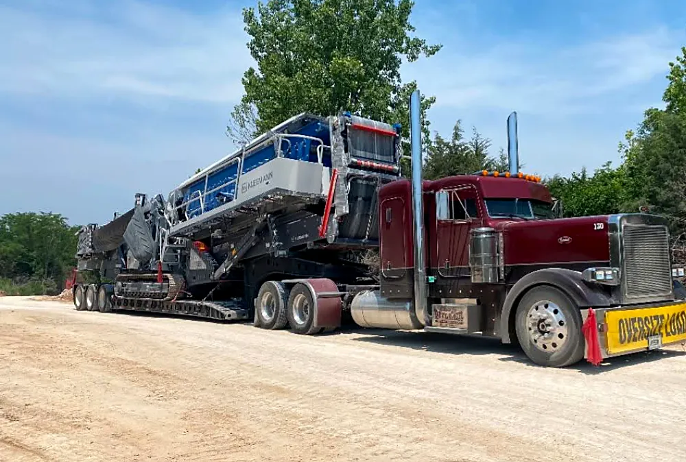 Lowboy trailer hauling heavy equipment